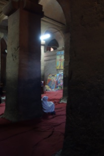 A worshiper in prayer inside Bet Medhane Alem.