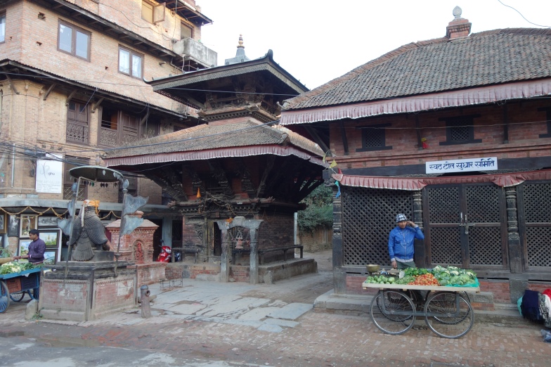 Produce vendor and a temple in the backstreets of Patan.
